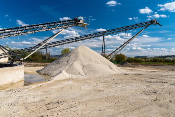 conveyor-over-heaps-of-gravel-on-blue-sky-at-an-industrial-cement-plant-