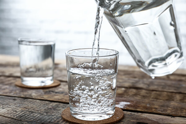 pouring-of-fresh-water-from-jug-into-glass-on-wood-2026-01-11-09-33-37-utc-2048×1365-1