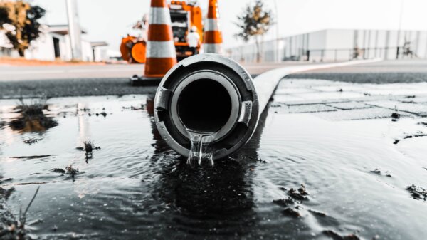 selective-closeup-shot-of-a-gray-pipe-with-water-coming-out-its-hole