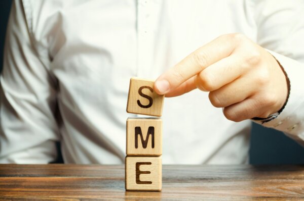 businessman-holds-wooden-blocks-with-the-word-sme