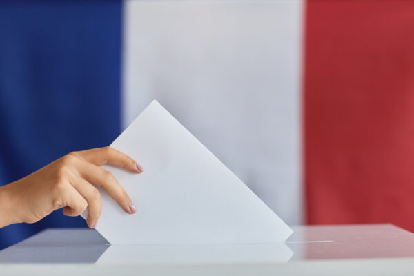 hand-placing-ballot-in-election-box-with-flag-2026-03-18-15-42-11-utc-2048×1365-1